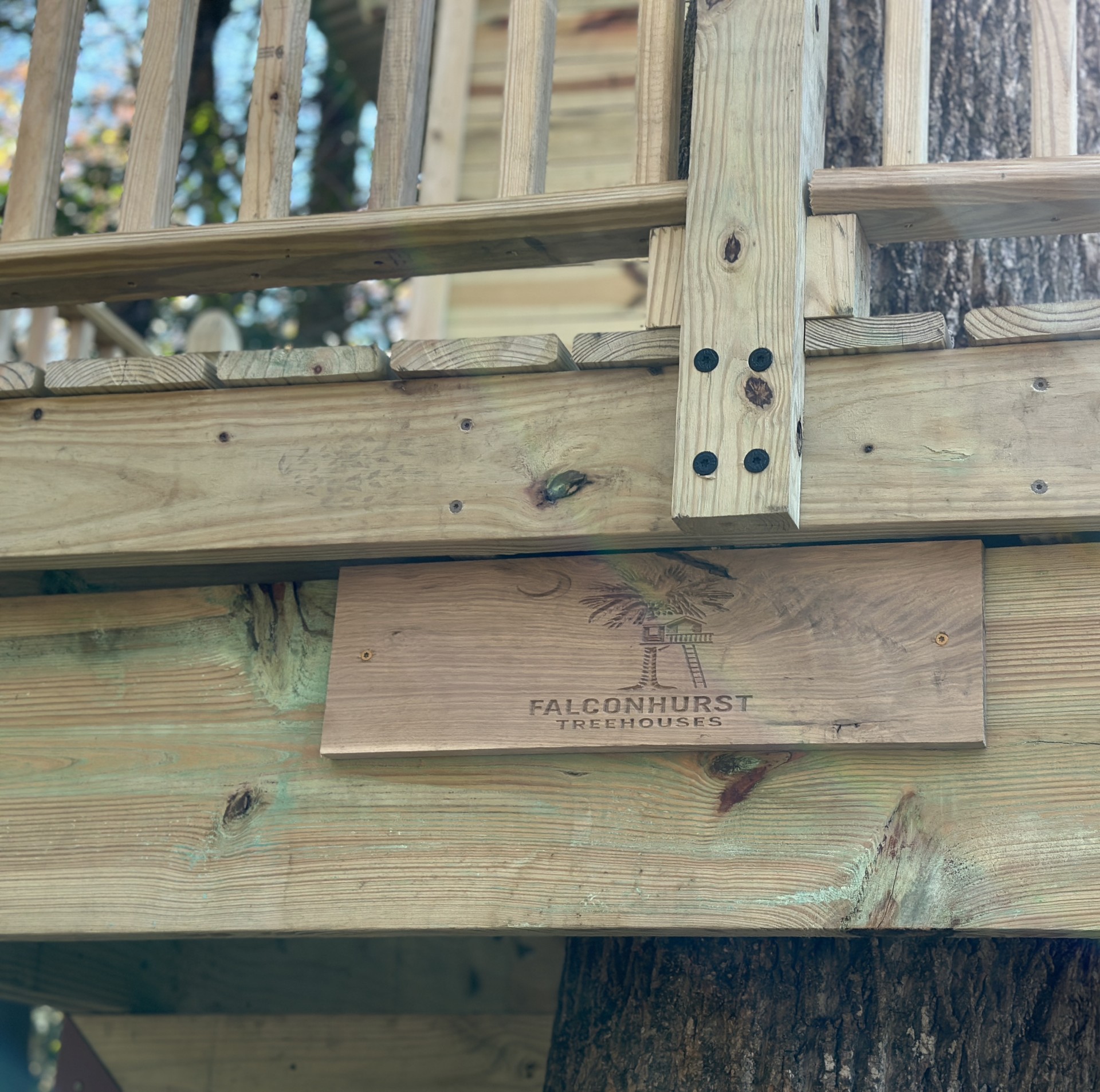 Close-up of a bolted post-and-beam joint with the Falconhurst maker plaque